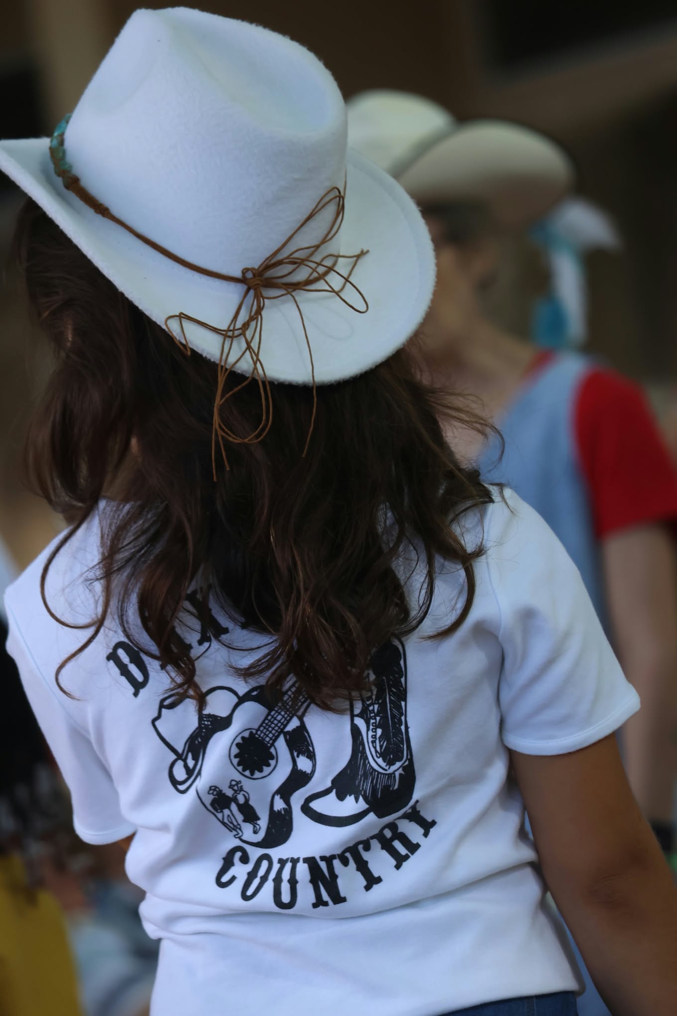 Femme de dos avec un chapeau blanc de style country