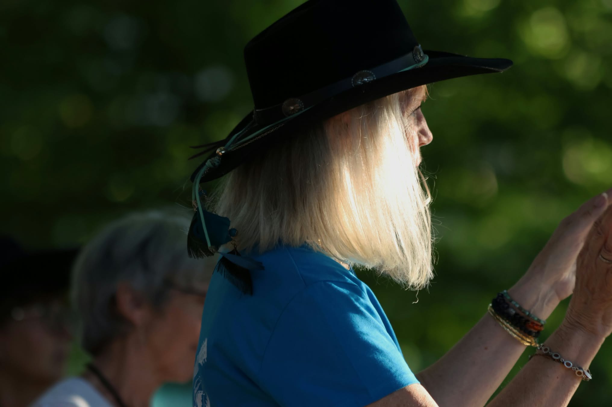 Femme blonde au chapeau noir dans la lumière